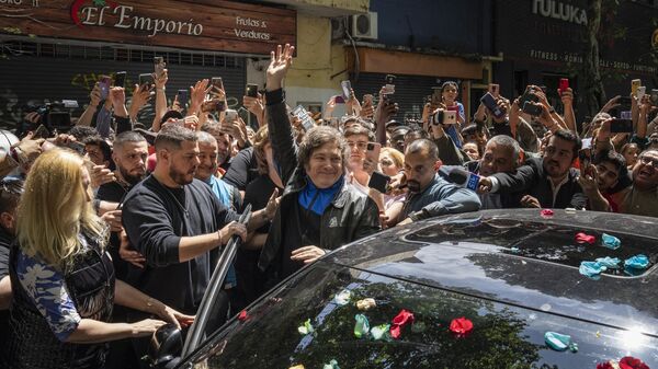 El candidato a la presidencia Javier Milei llega a votar en el barrio de Almagro. Sus seguidores lanzaron flores sobre su coche por el cumpleaños - Sputnik Mundo