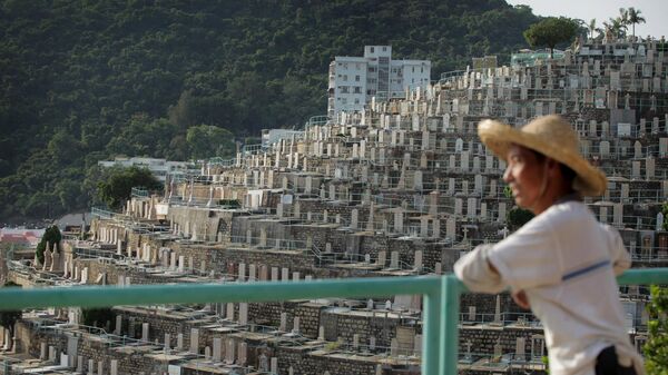Un hombre mirando el cementerio Pok Fu Lam en Hong Kong - Sputnik Mundo