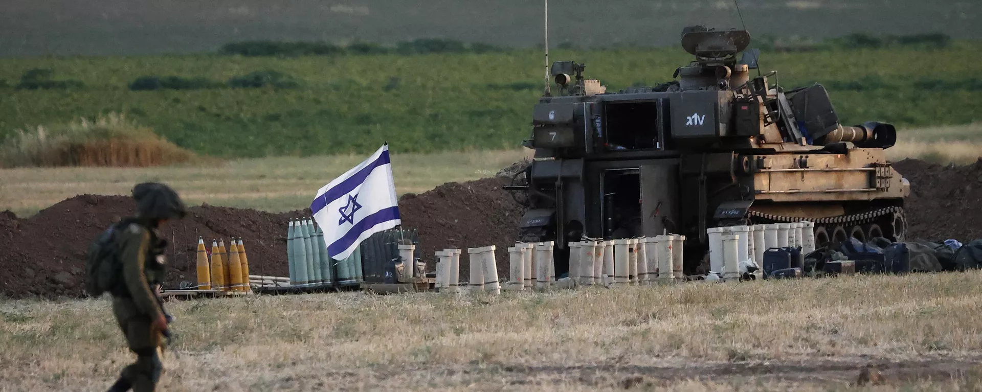 Un soldado israelí camina junto a un obús autopropulsado de 155 mm y otras municiones, en una posición del Ejército en la Franja de Gaza.  - Sputnik Mundo, 1920, 04.11.2023