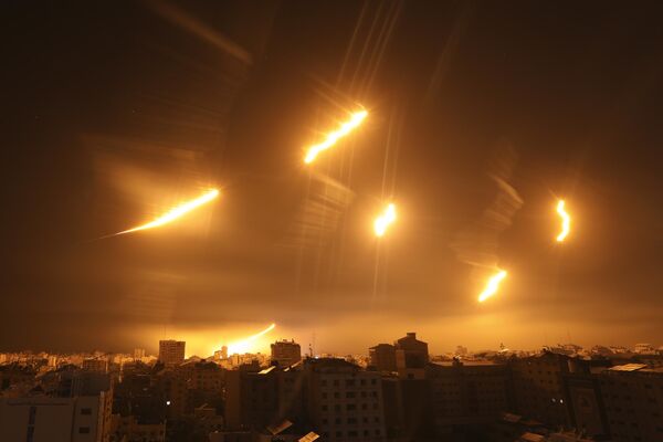 Esta foto de larga exposición muestra el cielo de Gaza iluminado por bengalas israelíes. - Sputnik Mundo