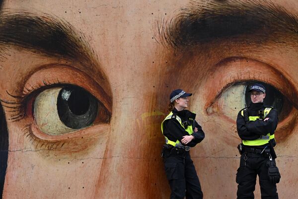 Agentes de Policía británicos ante una reproducción gigante del Retrato de un hombre de la artista italiana Antonella da Messina antes de una manifestación en apoyo a Palestina en Trafalgar Square, en el centro de Londres. - Sputnik Mundo
