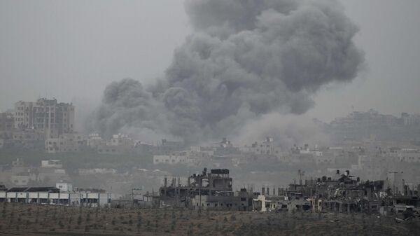 El humo se eleva tras un ataque aéreo israelí en la Franja de Gaza, visto desde el sur de Israel - Sputnik Mundo