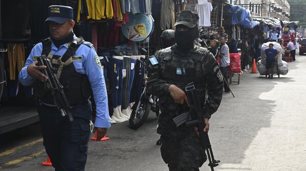 Un miembro del Ejército de Honduras y de la Policía Nacional patrullan una calle durante un operativo de seguridad denominado Mercados Seguros, en Tegucigalpa, el 14 de julio de 2023  - Sputnik Mundo