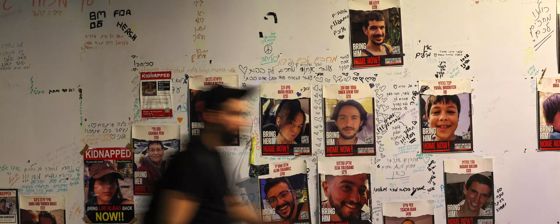 Un hombre camina junto a los retratos de rehenes israelíes colocados en una pared de Tel Aviv el 21 de noviembre de 2023, exigiendo la liberación de los israelíes retenidos como rehenes en Gaza desde el ataque el 7 de octubre Un hombre camina junto a los retratos de rehenes israelíes colocados en una pared de Tel Aviv el 21 de noviembre de 2023, exigiendo la liberación de los israelíes retenidos como rehenes en Gaza desde el ataque el 7 de octubre - Sputnik Mundo, 1920, 22.11.2023