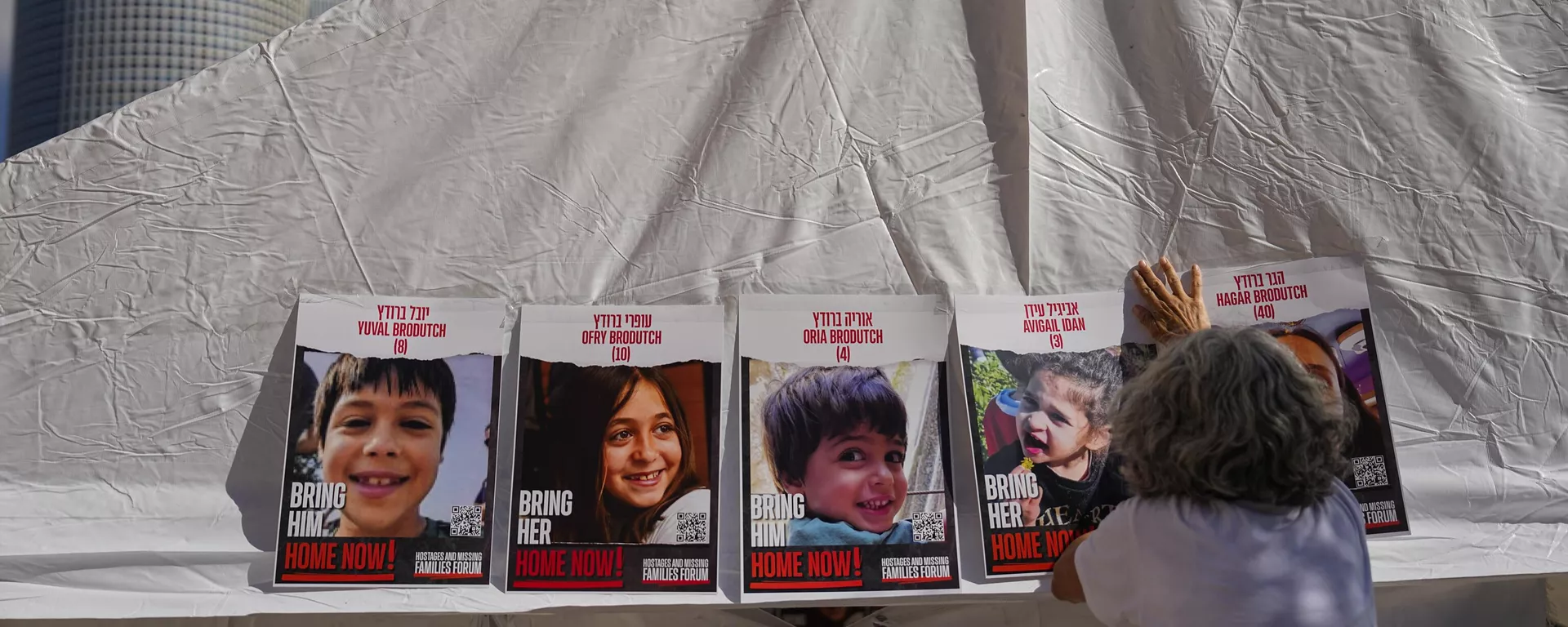 Una mujer pega fotos de israelíes desaparecidos y cautivos en Gaza - Sputnik Mundo, 1920, 22.11.2023