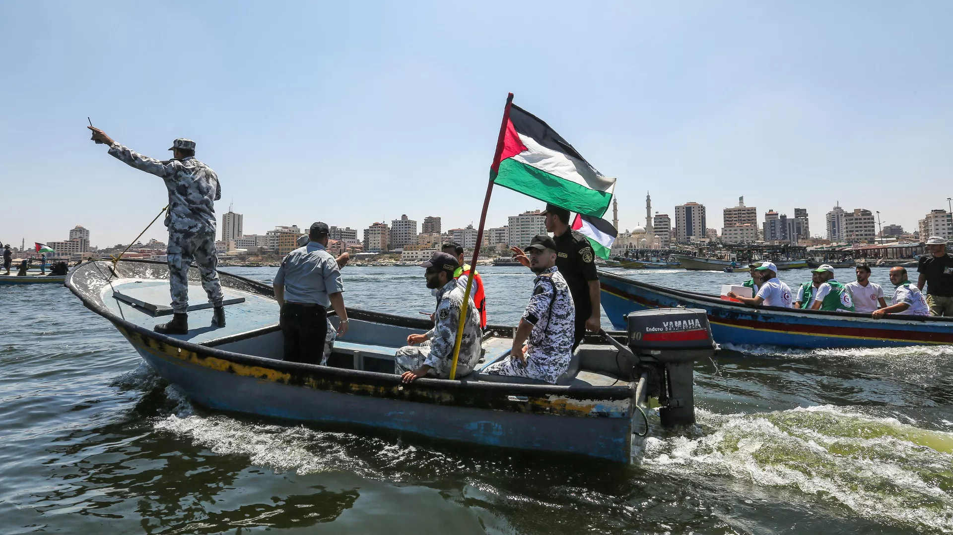 Una lancha con miembros de la policía marítima de Hamás se lanza al mar escoltando un bote de bloqueo que transporta a estudiantes palestinos y otros heridos durante las protestas desde el puerto de la ciudad de Gaza el 10 de julio de 2018 - Sputnik Mundo, 1920, 24.11.2023