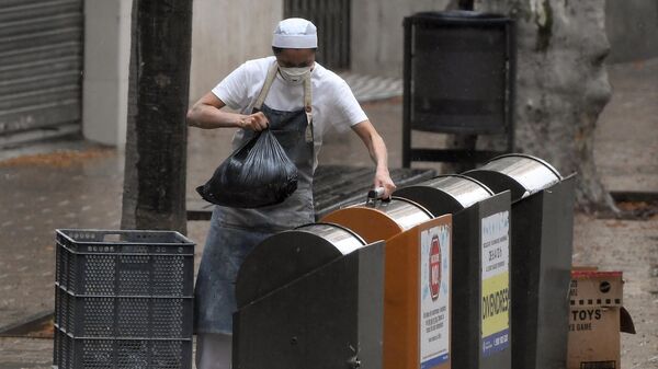 Una persona tira la basura en España - Sputnik Mundo