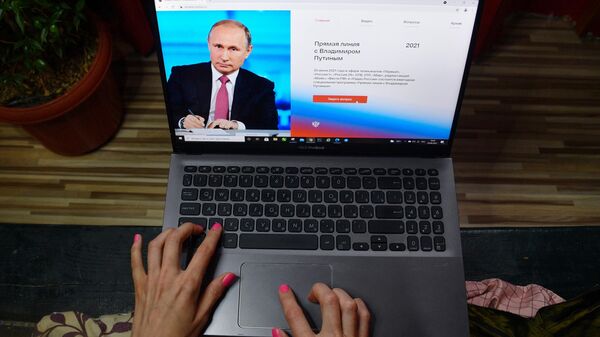 Una mujer ante un laptop preparando una pregunta para la línea directa del presidente de Rusia, Vladímir Putin - Sputnik Mundo