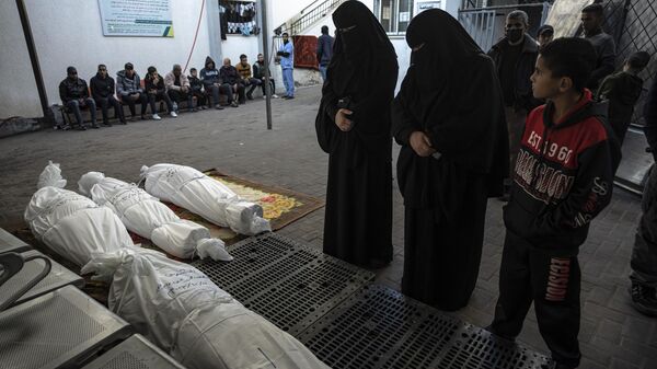 Mujeres palestinas lloran a sus familiares asesinados en el bombardeo israelí de la Franja de Gaza - Sputnik Mundo