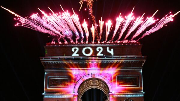 Fuegos artificiales estallan junto al Arco del Triunfo con 2024 proyectado, en la Avenida de los Campos Elíseos durante las celebraciones de Año Nuevo en París, el 1 de enero de 2024  - Sputnik Mundo