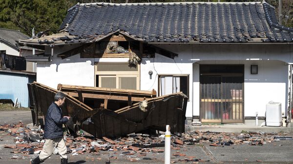 Hombre camina delante de su restaurante dañado en Shiroishi, prefectura de Miyagi, el 17 de marzo de 2022, después de que un terremoto de magnitud 7,3 sacudiera el este de Japón la noche anterior - Sputnik Mundo