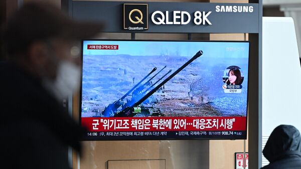 Un grupo de personas observa una pantalla de televisión que muestra un noticiario con imágenes de archivo de los disparos de artillería de Corea del Norte, en una estación de ferrocarril de Seúl, el 5 de enero de 2024  - Sputnik Mundo