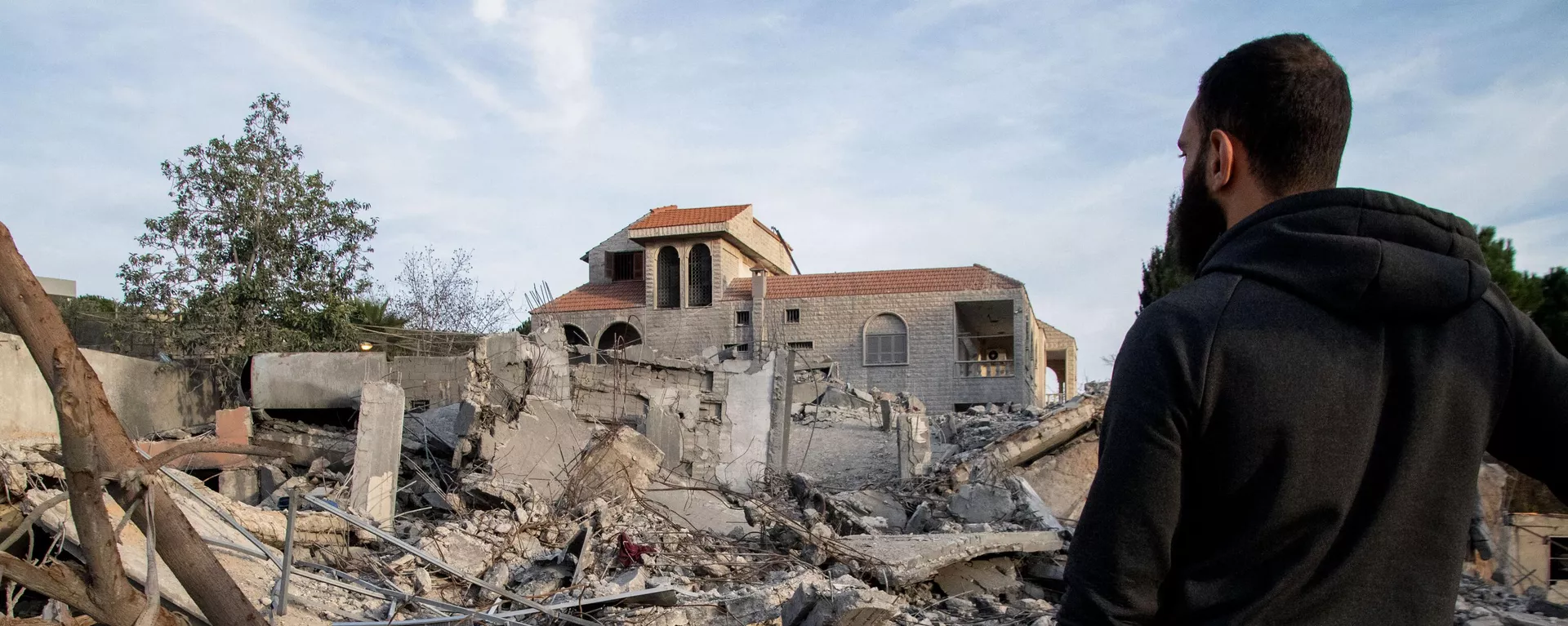 Un hombre comprueba un edificio destruido el 8 de enero de 2024 tras un ataque aéreo israelí en la aldea de Kfar Kila, en el sur del Líbano - Sputnik Mundo, 1920, 22.01.2024