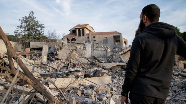 Un hombre comprueba un edificio destruido el 8 de enero de 2024 tras un ataque aéreo israelí en la aldea de Kfar Kila, en el sur del Líbano  - Sputnik Mundo