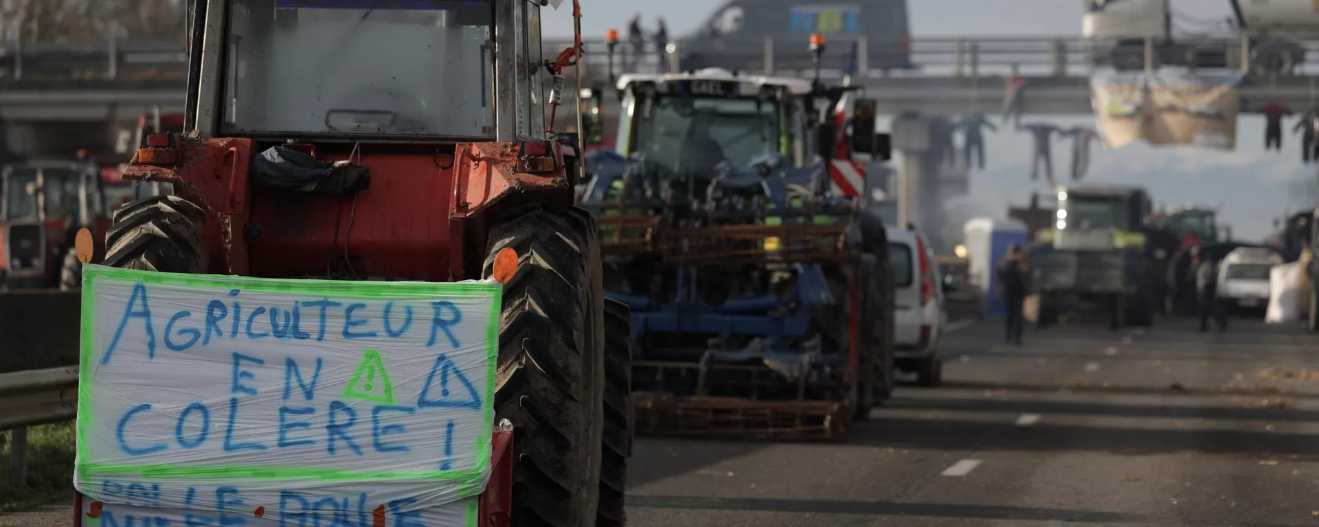 Un tractor con una pancarta en la que se lee agricultor enfadado en protesta por los impuestos y la disminución de ingresos, al sur de Toulouse, Francia - Sputnik Mundo, 1920, 31.01.2024