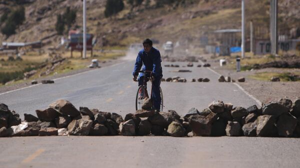 Un hombre conduce su bicicleta a través de un bloqueo de carreteras  - Sputnik Mundo