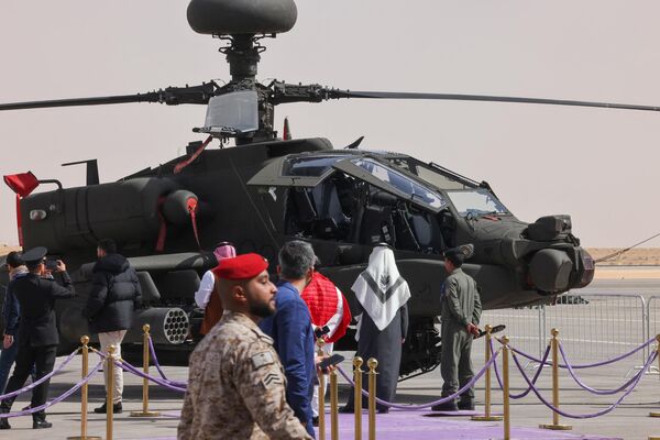 Además de 700 expositores, en el evento participan 115 delegaciones internacionales.En la foto: los visitantes observan un helicóptero de ataque AH-64 Apache de la Real Fuerza Aérea Saudita. - Sputnik Mundo