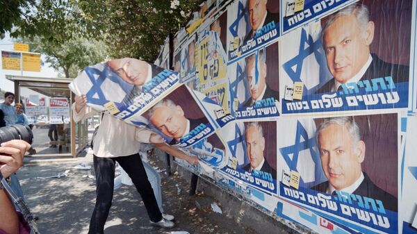 Una persona inconforme retira propaganda del primer ministro israelí Benjamín Netanyahu en Jerusalén - Sputnik Mundo