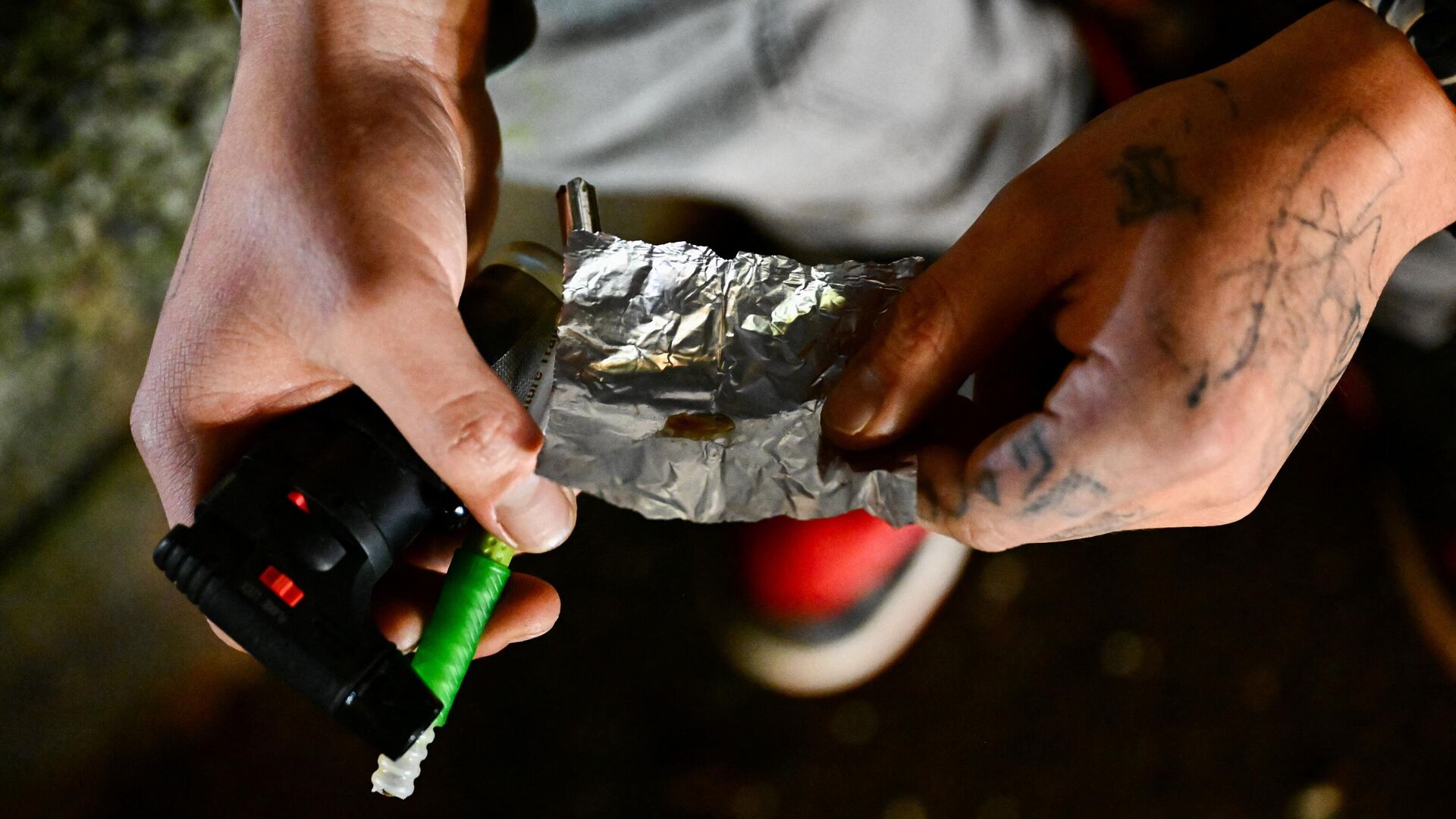 Una persona sostiene un papel de aluminio mientras fuma fentanilo en Park Avenue tras la despenalización de todas las drogas en el centro de Portland, Oregón, el 23 de enero de 2024. - Sputnik Mundo, 1920, 08.02.2024