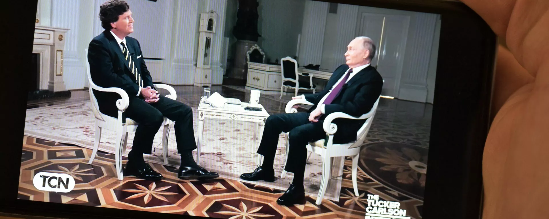 La vista de un móvil durante la transmisión de la entrevista de Tucker Carlson con el presidente ruso Vladímir Putin - Sputnik Mundo, 1920, 09.02.2024