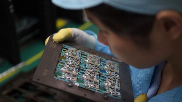 Circuitos de componentes de chips de smartphones son manipulados por un trabajador en la fábrica de Oppo en Dongguan, China  - Sputnik Mundo