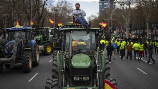 Un agricultor se sienta encima de un tractor durante una protesta ante la sede del Parlamento Europeo en Madrid, España, el 26 de febrero de 2024 - Sputnik Mundo