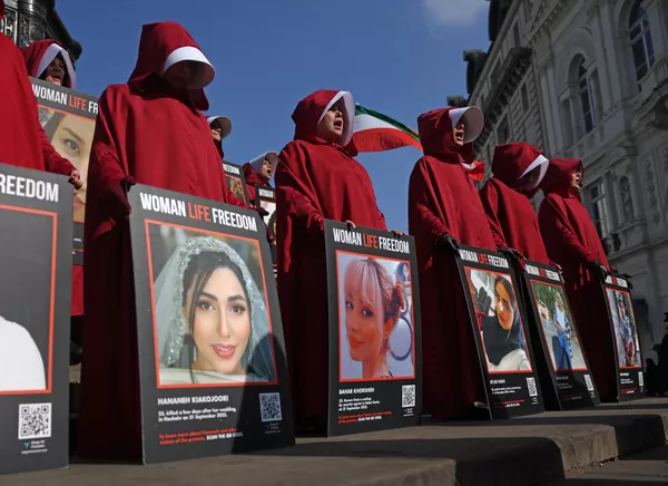 Manifestantes vestidas en el estilo de la serie de televisión El cuento de la criada sostienen grandes pancartas con imágenes de mujeres, durante una concentración en defensa de los derechos de la mujer el 8 de marzo en Londres, el Reino Unido. - Sputnik Mundo