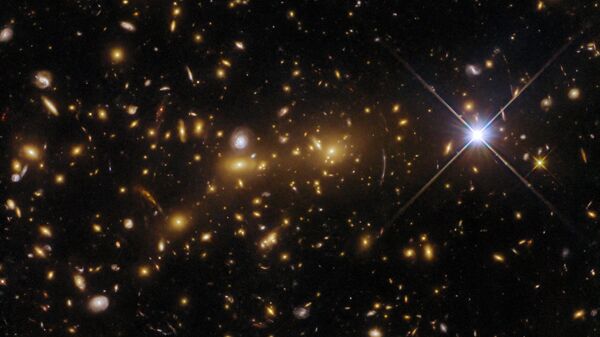 El telescopio espacial Hubble ha registrado un cúmulo de galaxias, eMACS J1353.7+4329, a unos 8.000 millones de años luz de la Tierra, que se está fusionando para formar un cúmulo masivo, que actúa como lente gravitatoria - Sputnik Mundo