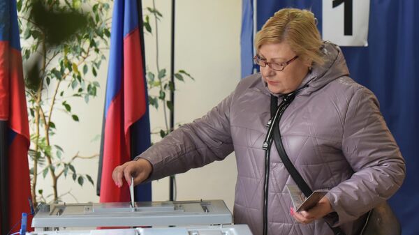 Una mujer vota en las elecciones presidenciales rusas en un colegio electoral de Donetsk, el 16 de marzo de 2024 - Sputnik Mundo
