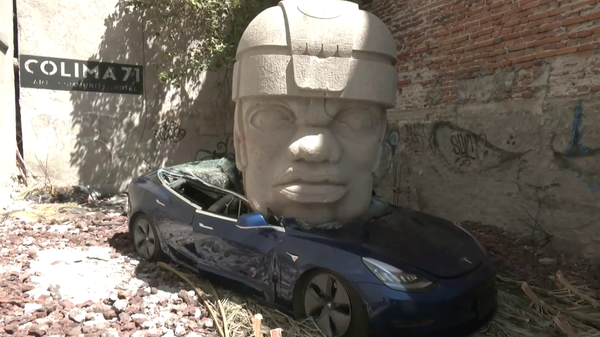 Artista mexicano aplasta un Tesla de lujo con una cabeza prehispánica gigante - Sputnik Mundo
