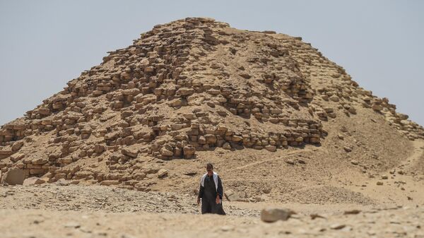 Un hombre camina frente a uno de los satélites de la pirámide Bent, en la antigua necrópolis real de Dahshurb - Sputnik Mundo