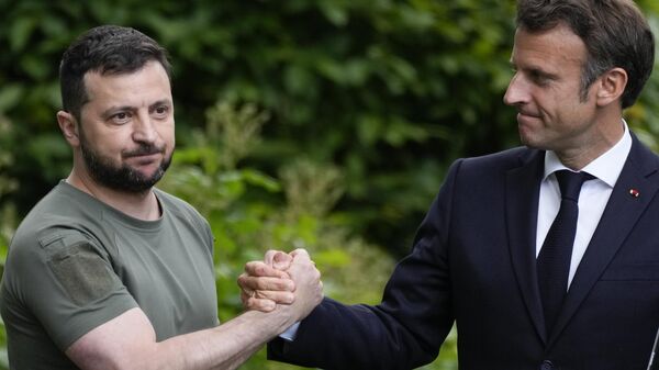 Volodímir Zelenski (izquierda) y Emmanuel Macron (derecha) estrechan sus manos  - Sputnik Mundo