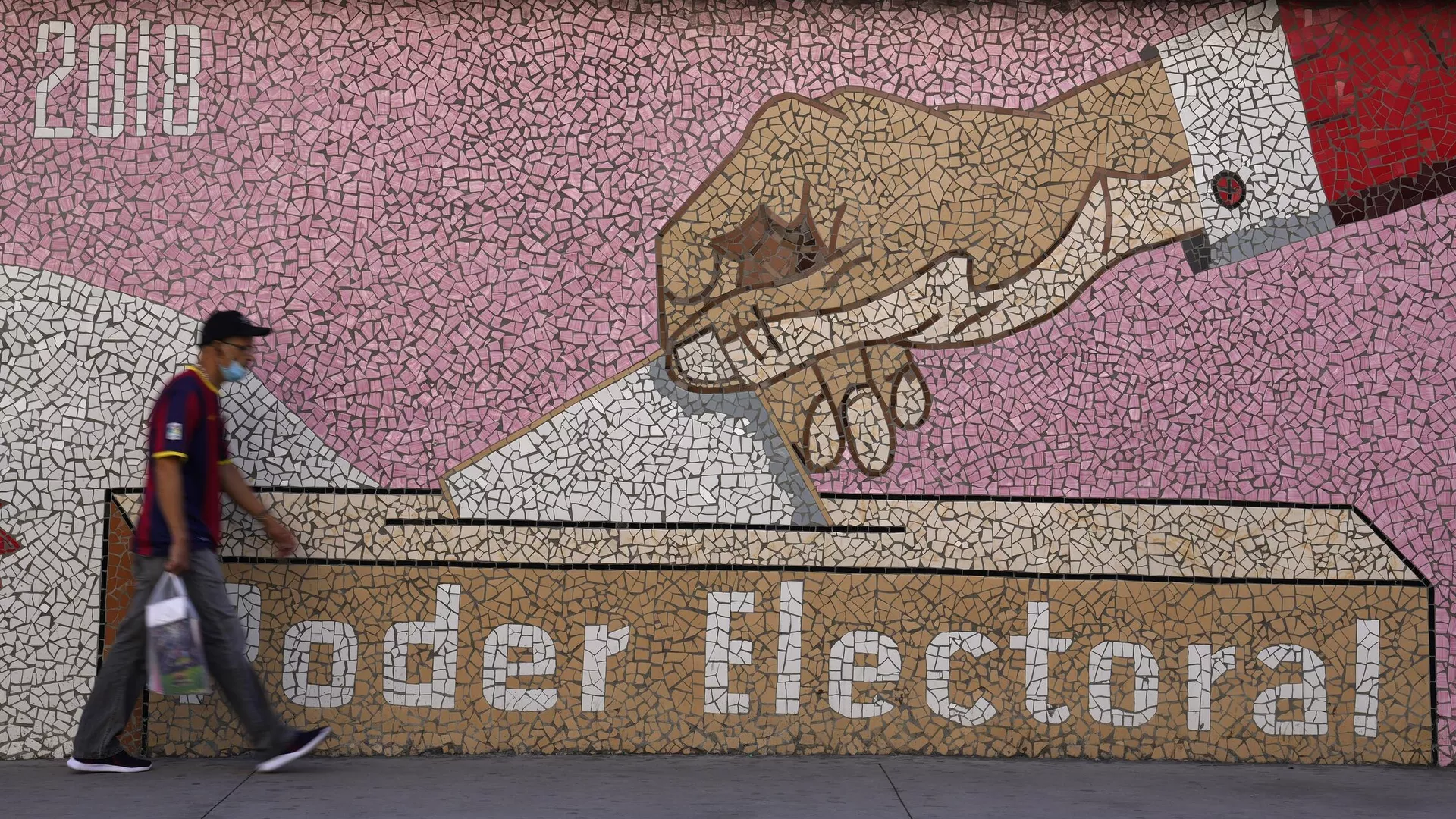 Un hombre camina junto a un mural con la imagen de una papeleta siendo emitida y las palabras en español Poder Electoral, en Caracas, Venezuela, el 30 de noviembre de 2021  - Sputnik Mundo, 1920, 28.03.2024