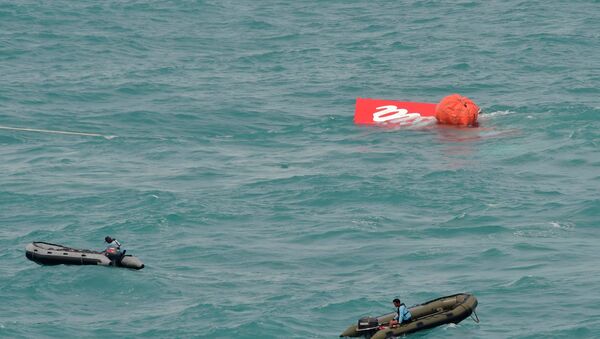 Part of the tail of AirAsia QZ8501 floats on the surface after being lifted as Indonesian navy divers conduct search operations for the black box flight recorders and passengers and crew of the aircraft, in the Java Sea January 10, 2015. - Sputnik Mundo