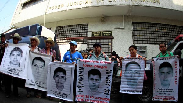 Familiares sostienen carteles de los 43 estudiantes desaparesidos - Sputnik Mundo