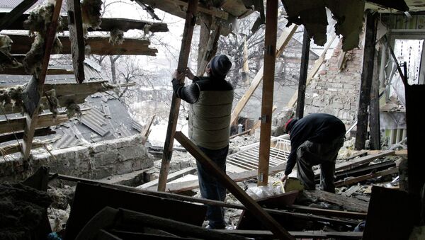 Local residents remove debris at a house damaged by recent shelling in Donetsk, eastern Ukraine, January 21, 2015 - Sputnik Mundo