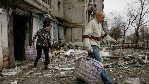 Local residents leave a residential block during a recent shelling, in the town of Yenakieve, February 2, 2015 - Sputnik Mundo