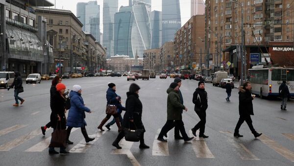 La gente cruza la calle, mientras los edificios del centro de negocios internacional de Moscú se ve en el fondo - Sputnik Mundo