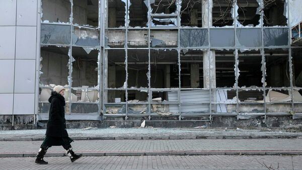 A woman walks by a building, which was damaged by shelling last September, in Donetsk, February 15, 2015 - Sputnik Mundo