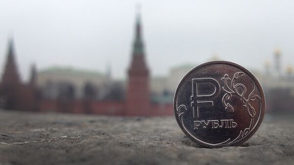 Una moneda de rublo con el Kremlin de Moscú de fondo - Sputnik Mundo