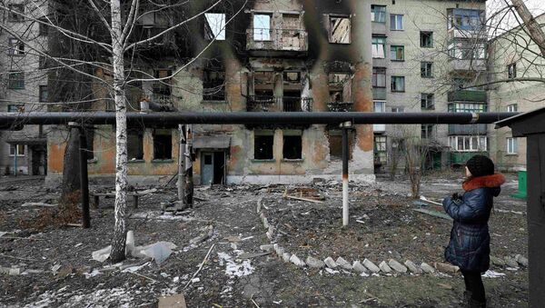A woman looks at a building damaged by fighting in the city of Debaltseve, February 20, 2015 - Sputnik Mundo