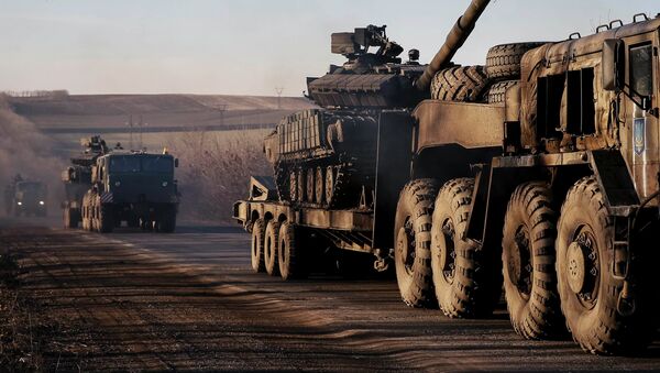 Military trucks from the Ukrainian armed forces transport tanks on the road near Artemivsk, eastern Ukraine, February 24, 2015 - Sputnik Mundo