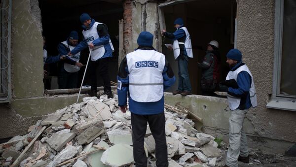Organization for Security and Co-operation in Europe (OSCE) monitors investigate outside a kindergarten damaged in Saturday's shelling in which scores of people were killed and injured in Mariupol - Sputnik Mundo