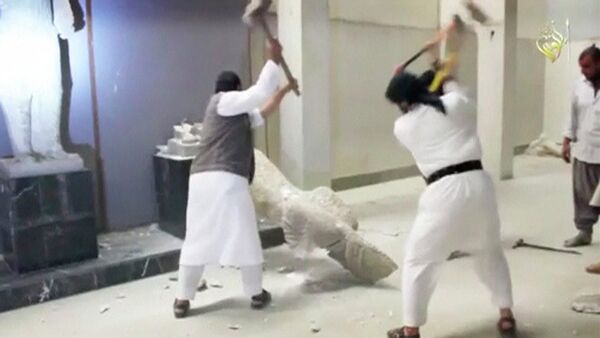Men use sledgehammers on a toppled statue in a museum at a location said to be Mosul - Sputnik Mundo