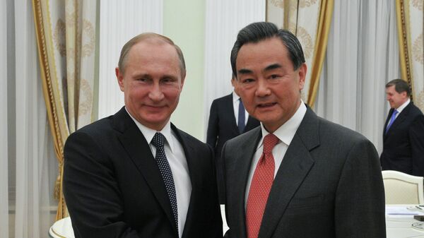 Vladímir Putin, presidente de Rusia y Wang Yi, ministro de Asuntos Exteriores de China - Sputnik Mundo
