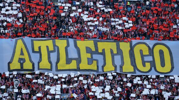 Atletico fans hold up placard in their club colours and the team name - Sputnik Mundo