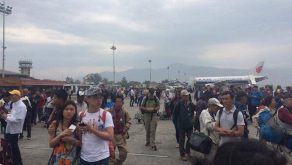 Gente a la pista de la terminal internacional después de un terremoto en Kathmandu - Sputnik Mundo