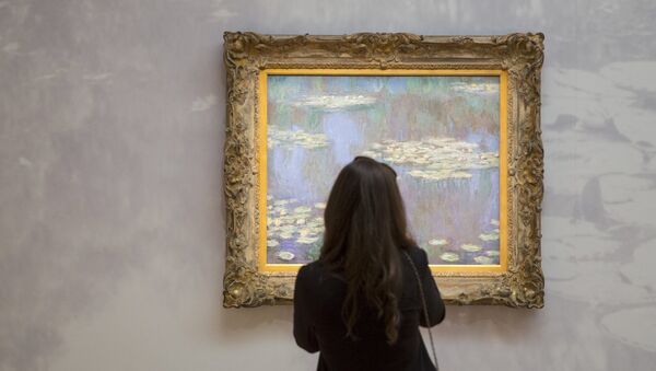 A woman views an example of Claude Monet's Water Lilies, estimated between $35-40 million, ahead of a preview event to Sotheby's upcoming evening's of impressionist, modern and contemporary art in the Manhattan borough of New York City May 1, 2015. - Sputnik Mundo