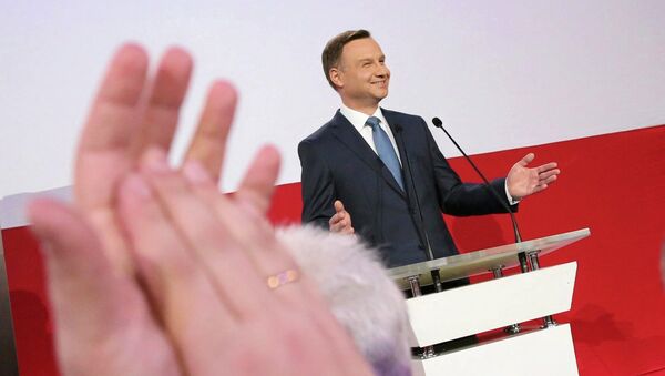 A supporter applauds Andrzej Duda, presidential candidate of the Law and Justice Party (PiS) after the exit polls on the second round of presidential elections in Warsaw - Sputnik Mundo