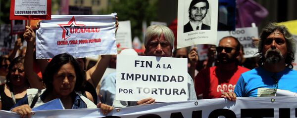 Manifestantes con fotos de las víctimas de la dictadura de Augusto Pinochet (archivo) Manifestantes con fotos de las víctimas de la dictadura de Augusto Pinochet (archivo) - Sputnik Mundo